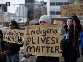 People gather with signs during a rally in response to Gerald Stanley's acquittal in the shooting death of Colten Boushie in Edmonton, Alta., on Saturday, February 10, 2018.