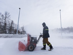 Dan Healy uses a snow blower to clear snow from the Cloverdale community rink on Saturday, Feb. 3, 2018 in Edmonton.