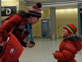 Olympic hockey goalie Shannon Szabados is greeted by a young fan at Edmonton International Airport on Monday, Feb. 26, 2018, after returning from the Winter Olympic Games in Korea where she and the Canadian women's hockey team captured the silver medal.