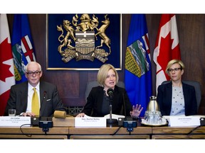 Former Syncrude Canada president Jim Carter, left, and Husky Energy senior vice-president Janet Annesley, right, listen as Alberta Premier Rachel Notley speaks at the first meeting of the Market Access Task Force in Edmonton, Alta., on Wednesday, Feb. 14, 2018.