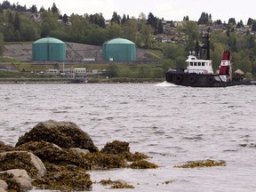 A tug boat is seen passing the Kinder Morgan Marine Terminal on the south shore of Burrard Intlet just outside of Vancouver. File photo.