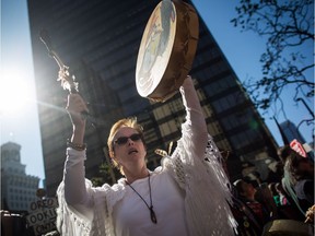 A woman sings and plays a drum during a rally outside Federal Court where a hearing about the Kinder Morgan Trans Mountain pipeline expansion is taking place, in Vancouver, B.C., on Monday October 2, 2017. The hearing which began Monday consolidates numerous lawsuits filed by seven First Nations applicants, the cities of Burnaby and Vancouver, the Raincoast Conservation Foundation, and the Living Oceans Society, which claim the National Energy Board's approval process was flawed and First Nations weren't adequately consulted.