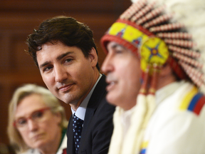 Minister of Indigenous and Northern Affairs Carolyn Bennett and Prime Minister Justin Trudeau listen as Assembly of First Nations Chief Perry Bellegarde speaks in the House of Commons.