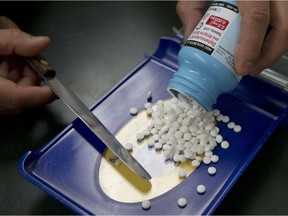 A pharmacy technician fills a prescription. File photo.