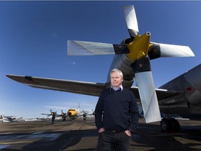 Air Spray Ltd. chief operating officer Paul Lane in front of two Lockheed Electras being tested on the tarmac at the company's operations centre in Red Deer on March 28, 2018.