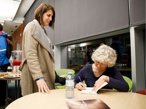 Alice Major signs Rayanne Haines' copy of her book during the book launch for Welcome to the Anthropocene at the University of Alberta Observatory in Edmonton on Thursday, March 1, 2018.