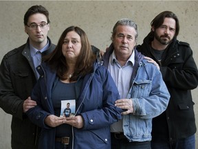 Stephen Penny's parents Debbie Penny and Glen Penny and his brothers Brian Penny (left) and Mike Penny hold a photo of Stephen outside the Law Courts in Edmonton Monday, March 5, 2018. Stephen Penny was a City of Edmonton worker who was killed on the job in 2015.