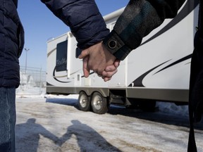 A couple (declined to be identified) who were the victim of fraud when they accidentally purchased a stolen RV. pose for a photo at the police vehicle seizure lot in Edmonton Monday March 12, 2018.