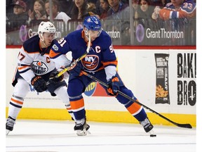 Oilers captain Connor McDavid, left, of the Edmonton Oilers battles against John Tavares of the New York Islanders at the Barclays Center on November 7, 2017.