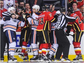 The Calgary Flames mix it up after the whistle with the Edmonton Oilers during an NHL game at Scotiabank Saddledome on March 13, 2018.