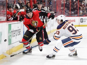 OTTAWA, ON - MARCH 22: Cody Ceci #5 of the Ottawa Senators chips the puck past Ryan Nugent-Hopkins #93 of the Edmonton Oilers in the second period at Canadian Tire Centre on March 22, 2018 in Ottawa, Ontario, Canada.