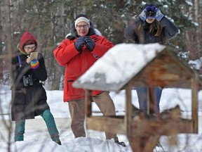 Caitlin Mader, left, John Acorn and Amelie Roberto-Charron watch birds at a feeder in Hawrelak Park during the 64th Annual Edmonton Christmas bird count where volunteers head out to count birds in and around Edmonton on Dec. 16, 2012.