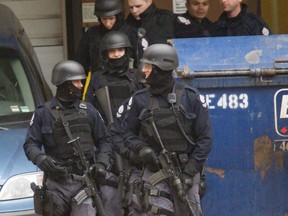 Police tactical team members leave the Workers Compensation Board building in Edmonton, Alberta on Wednesday, October 21, 2009. A man who took nine people hostage at gunpoint in Edmonton is again eligible for statutory release but he will be required to return to a half-way house each night and abide by seven other conditions.