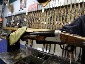The Liberal government is planning to introduce long-promised legislation as early as Tuesday to strengthen controls on the sale, licensing and tracing of guns. A Ottawa hunting store salesperson wipes a shotgun on Tuesday, May 16, 2006.