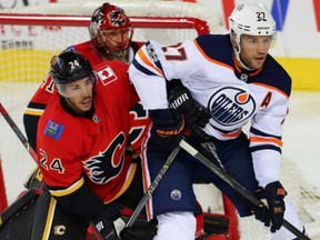 Calgary Flames defenceman Travis Hamonic battles Milan Lucic of the Edmonton Oilers during NHL action at the Scotiabank Saddledome in Calgary on September 18, 2017.