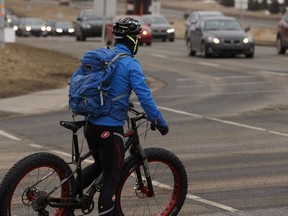 A cyclist rides in congested rush hour traffic at the intersection of Terwillegar Drive and 40 Avenue in Edmonton.