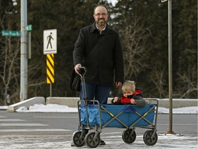 Neil Carey and his son Aidan, three, wait to cross at a pedestrian crosswalk at 148 Street and Stony Plain Road on his way to daycare which takes him past the proposed west LRT line. He's concerned the focus on impacts to vehicle traffic is drowning out questions on urban design and walkability.