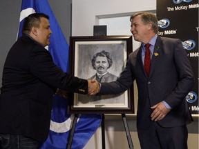 President of the Fort McKay Metis Ron Quintal, left, and Alberta Minister of Indigenous Relations Richard Feehan shake hands after announcing a $1.6-million land deal in Edmonton on March 28, 2018.