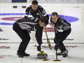 Winnipeg's Mike McEwen follows his front end of lead Denni Neufeld, right, and second Matt Wozniak, during the wild card sudden death game against fellow skip Jason Gunnlaugson at the Tim Hortons Brier on March 2, 2018. (Michael Burns/Postmedia Network)