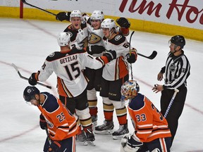 Edmonton Oilers Darnell Nurse (25) and goalie Cam Talbot (33) skate off the ice as Anaheim Ducks celebrates their overtime goal during NHL action at Rogers Place in Edmonton, March 25, 2018.