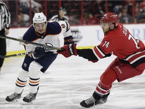 Edmonton Oilers' Ty Rattie (8) passes the puck while Carolina Hurricanes' Jaccob Slavin (74) defends during the first period of an NHL hockey game in Raleigh, N.C., Tuesday, March 20, 2018.