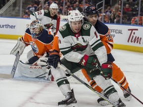 Darnell Nurse of the Edmonton Oilers, hangs onto Zach Parise of the Minnesota Wild at Rogers Place in Edmonton on March 10, 2018.