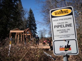 A sign warms of an underground pipeline as people construct a 'watch house' near a gate leading to Kinder Morgan's property during a protest against the company's Trans Mountain pipeline expansion in Burnaby on March 10.