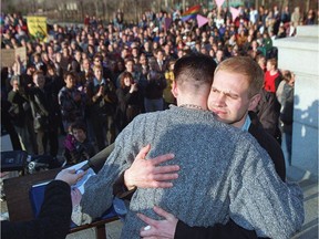 Delwin Vriend hugs his companion Andrew Gagnon during a rally, April 2, 1998, outside the Alberta legislature.