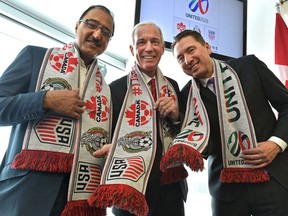Showing off their soccer bid scarves from left, Amarjeet Sohi, Minister of Infrastructure and Communities, left, Steven Reed, president of Canada Soccer and co-chair of the United 2026 Bid Committee, and Coun. Michael Walters were at Commonwealth Stadium in Edmonton on March 16, to announce that Edmonton has been named as a host city for the 2026 FIFA World Cup that would take place in Canada, Mexico and United States.