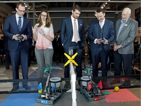 Officials play with remote-controlled robots at NAIT on Wednesday, March 14, 2018 after the province announced new seats for students in the technology sector. Left to right: Minister of Advanced Education Marlin Schmidt, NAIT graduate Erin Wilson, Promethean Labs CEO Zachary Fritze, Minister of Economic Development and Trade Deron Bilous, and NAIT technology coordinator Neil Wenger.