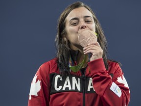 In this Aug. 18, 2016 file photo, Canadian Commonwealth Games flag bearer Meaghan Benfeito celebrates her bronze medal in women's 10m diving at the Rio Olympics.