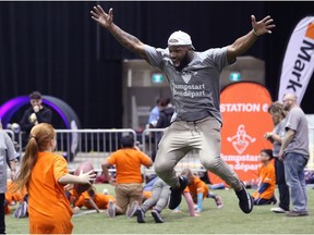 Hamilton Tiger-Cats linebacker Simoni Lawrence celebrates with a student during a Jumpstart event at the RBC Convention Centre that is part of CFL Week in Winnipeg on Thurs., March 22, 2018. Over 150 kids from Greenway and Victory schools were able to participate in drills with current CFL stars. Kevin King/Winnipeg Sun/Postmedia Network