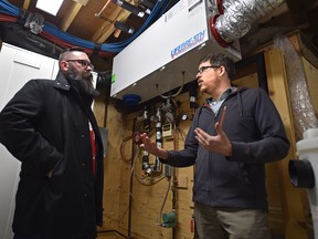 Municipal Affairs Minister Shaye Anderson, left, is shown energy efficient features in the basement of homeowner Conrad Nobert in Edmonton on Thursday, April 12, 2018.