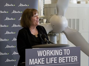 A wind turbine is visible behind Minister of Energy Margaret McCuaig-Boyd, as she announces the next stage of private-sector competitions under Alberta's Renewable Electricity Program in the Alternative Energy Technology Lab at NAIT, in Edmonton Wednesday April 4, 2018.