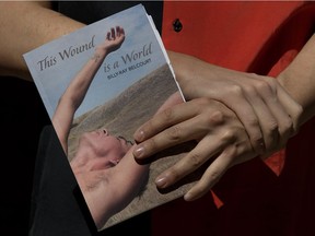 Poet Billy-Ray Belcourt holds his book of poetry, This Wound is a World.