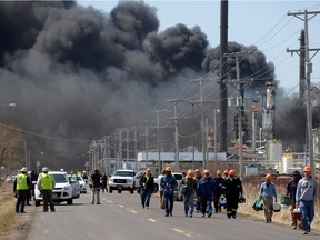 Workers evacuate from an explosion and fire at the Husky Energy oil refinery in Superior, Wisconsin on April 26, 2018.