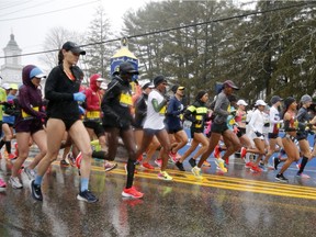 The elite female runners break from the starting line in a downpour during the 122nd running of the Boston Marathon in Hopkinton, Mass., Monday, April 16, 2018.