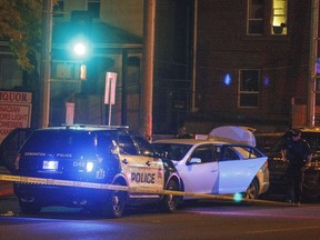 Police investigate the scene where a car crashed into a roadblock in Edmonton, Alta, on Saturday, Sept. 30, 2017. Police say a vehicle rammed a traffic control barricade and sent an officer flying into the air.