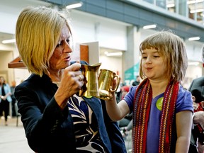 Premier Rachel Notley (left) shares a toast with Morgan Stevens, 3, at NorQuest College in Edmonton on Wednesday, April 25, 2018, where she announced a major expansion of the $25-a-day child care pilot program.