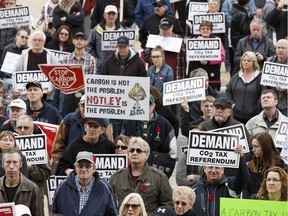 Demonstrators hold anti-carbon tax signs during a rally held at the Alberta Legislature in Edmonton, Alberta on Saturday, Nov. 5, 2016.