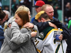 Mourners comfort each other as people attend a vigil at the Elgar Petersen Arena, home of the Humboldt Broncos, to honour the victims of a fatal bus accident in Humboldt, Sask. on Sunday, April 8, 2018.