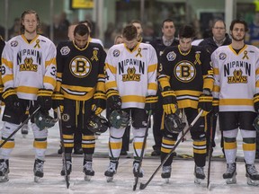 In this April 14 file photo, Nipawin Hawks and Estevan Bruins players pause for a moment of silence to acknowledge first responders, victims, and survivors of the bus crash that killed 16 members of the Humboldt Broncos.