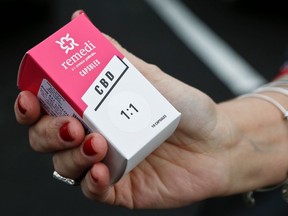 FILE - In this Thursday, Feb. 15, 2018 file photo, a woman holds the prescribed medical marijuana product used to treat her daughter's epilepsy after making a purchase at a medical marijuana dispensary in Butler, Pa. Two new studies released on Monday, April 2, 2018 suggest that legalization of marijuana may reduce the prescribing of opioids.