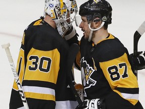 Pittsburgh Penguins' Sidney Crosby (87) congratulates goal tender Matt Murray (30) after a 7-0 shutout of the Philadelphia Flyers in Game 1 of an NHL first-round hockey playoff series in Pittsburgh, Wednesday, April 11, 2018. Crosby had his third career playoff hat trick in the game.