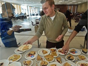Nick Seniuk, VP of Student Life planning events, hands out real pies slices for free to students and asked for donations to go towards Habitat for Humanity during Pi Day celebrations on 3/14, at the University of Alberta in Edmonton, March 14, 2018.