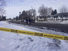 Edmonton police 
officers pick up evidence markers as homicide detectives probe an early morning shooting at 150 Avenue and 92 Street near the Evansdale Community League in Edmonton, AB on Sunday, April 8, 2018. (Photo by Paige Parsons)