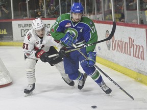 Tyler Steenbergen of the Swift Current Broncos fights off a check from Kale Clague of the Moose Jaw Warriors in Game 7 of their second-round WHL playoff series.