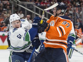 Connor McDavid of the Edmonton Oilers, collides with Troy Stecher of the Vancouver Canucks at Rogers Place in Edmonton on April 7, 2018. Photo by Shaughn Butts / Postmedia