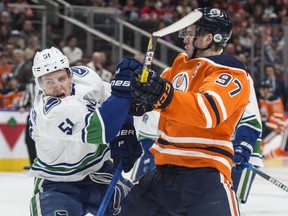 Connor McDavid of the Edmonton Oilers, collides with Troy Stecher of the Vancouver Canucks at Rogers Place in Edmonton on April 7, 2018.