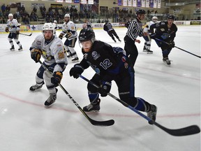 Spruce Grove Saints' Brad Forrest (28) and Wenatchee Wild's Josh Arnold (12) go after the puck along the boards during Game 4 of the Doyle Cup at Grant Fuhr Arena in Spruce Grove on May 2, 2018.